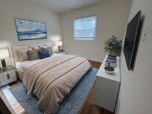 bedroom with dark hardwood / wood-style flooring