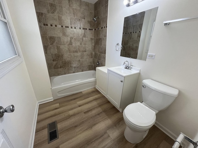 full bathroom featuring toilet, vanity, tiled shower / bath combo, and hardwood / wood-style flooring