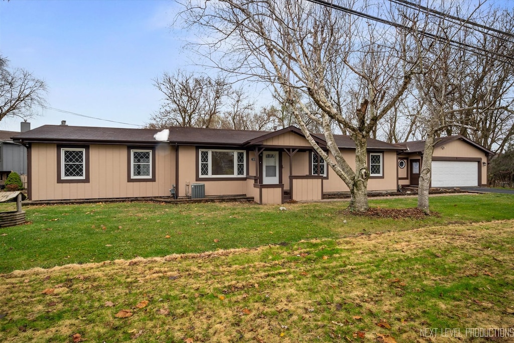 ranch-style house with a front lawn, central AC unit, and a garage