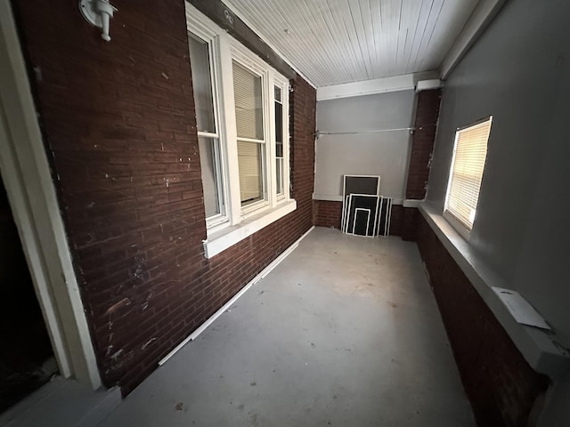 interior space featuring brick wall and concrete floors