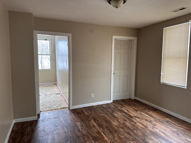 unfurnished bedroom with dark hardwood / wood-style flooring