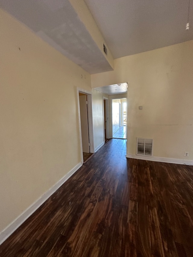 unfurnished room with dark wood-type flooring