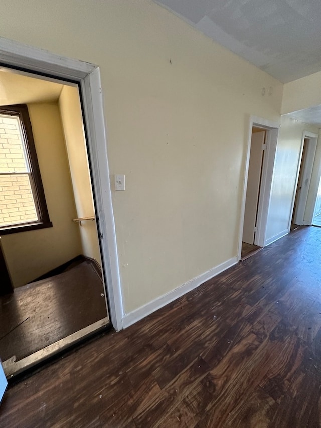 unfurnished room with dark wood-type flooring