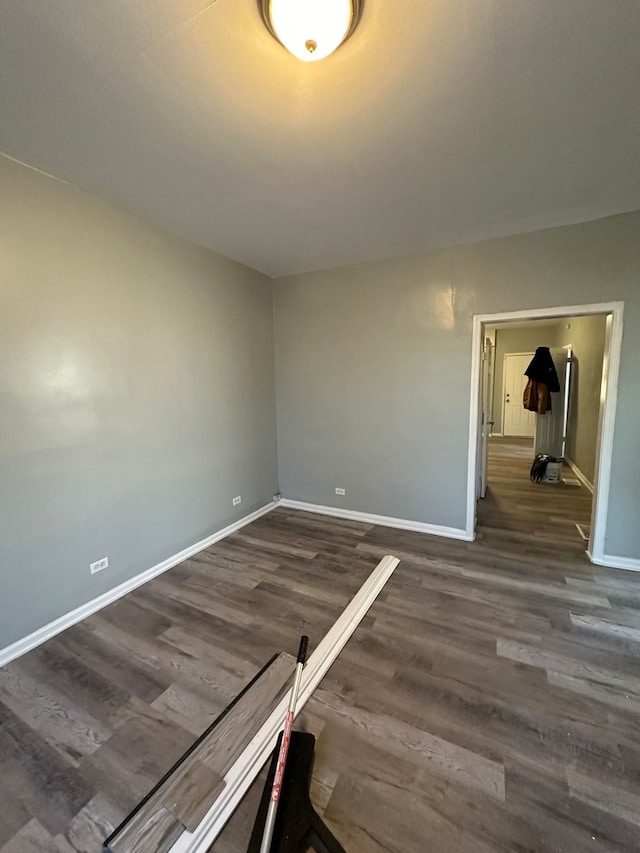 unfurnished room with dark hardwood / wood-style flooring