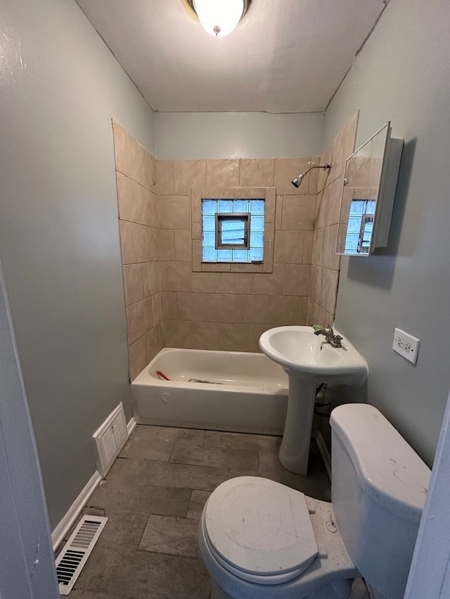 bathroom with tiled shower / bath and toilet