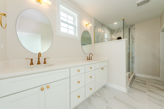 bathroom featuring a shower with shower door and vanity