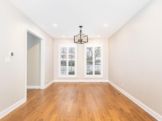 unfurnished dining area with light hardwood / wood-style flooring and an inviting chandelier