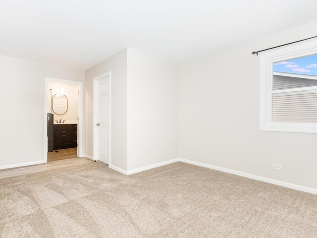 unfurnished room with sink and light colored carpet