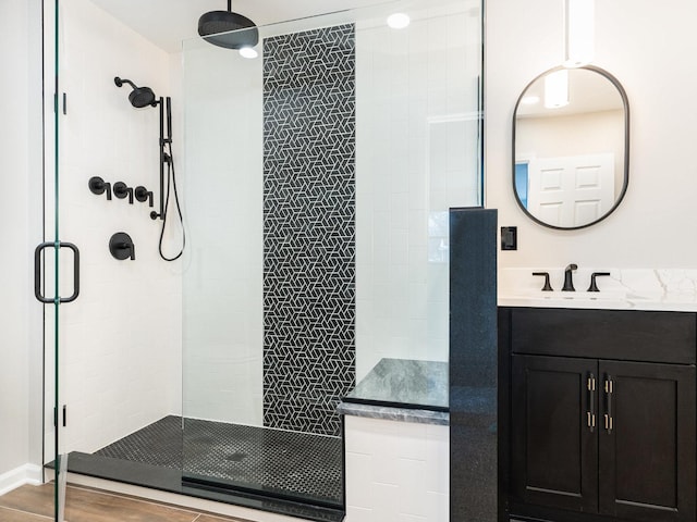 bathroom with hardwood / wood-style flooring, walk in shower, and vanity