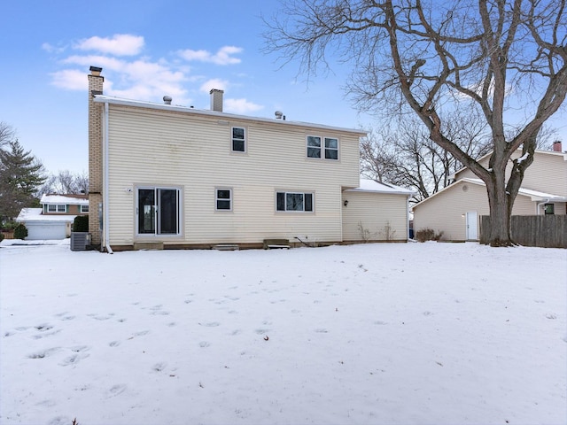 snow covered rear of property featuring cooling unit