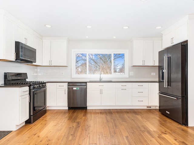 kitchen with sink, light hardwood / wood-style flooring, white cabinetry, and stainless steel appliances