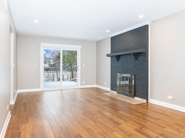 unfurnished living room with a brick fireplace and wood-type flooring