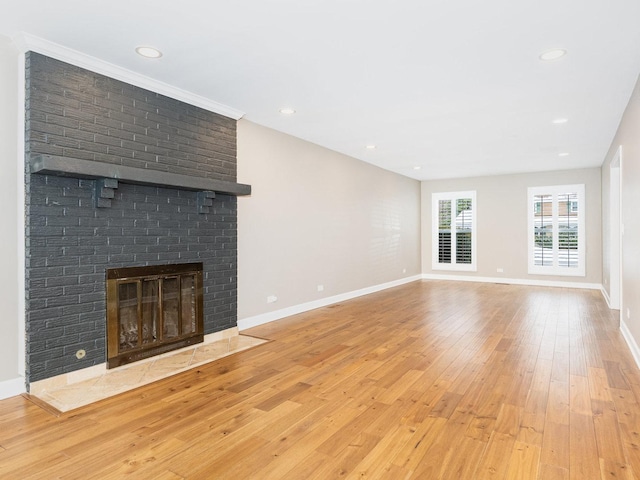 unfurnished living room featuring a fireplace and light hardwood / wood-style floors