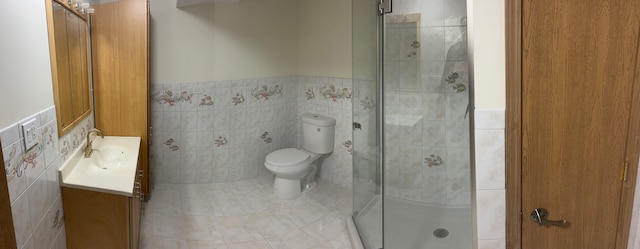 bathroom featuring toilet, vanity, and tile walls