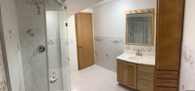 bathroom featuring walk in shower, vanity, and tile walls