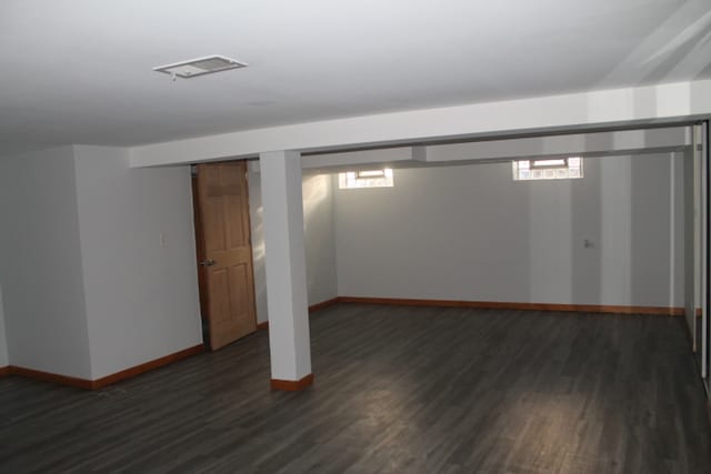 basement with dark hardwood / wood-style floors