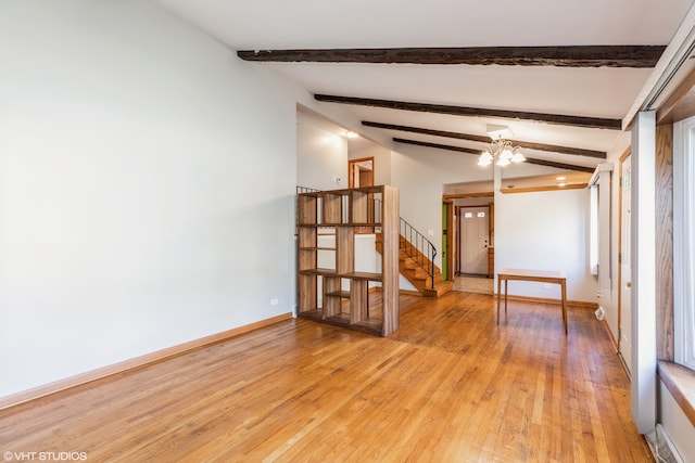 spare room with vaulted ceiling with beams, light hardwood / wood-style floors, and ceiling fan