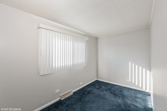 unfurnished room featuring dark colored carpet and crown molding