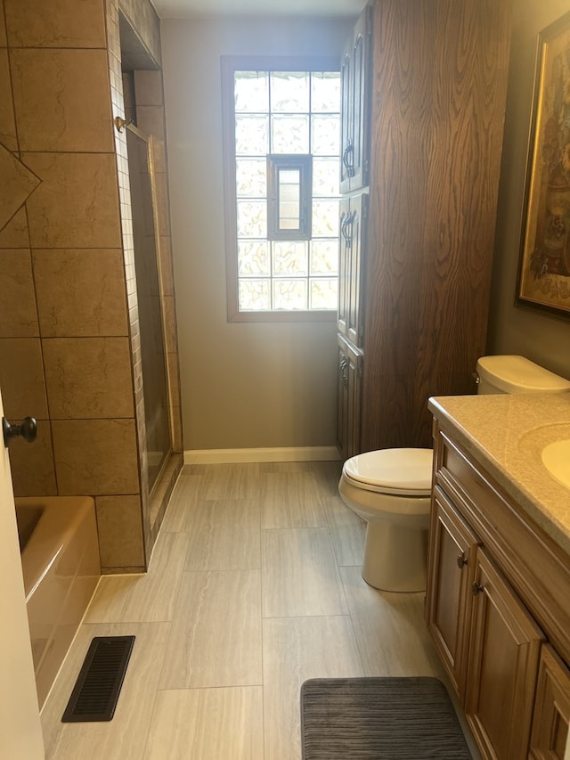 bathroom with visible vents, toilet, baseboards, walk in shower, and vanity