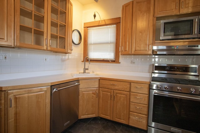 kitchen featuring sink, tasteful backsplash, dark tile patterned floors, extractor fan, and appliances with stainless steel finishes