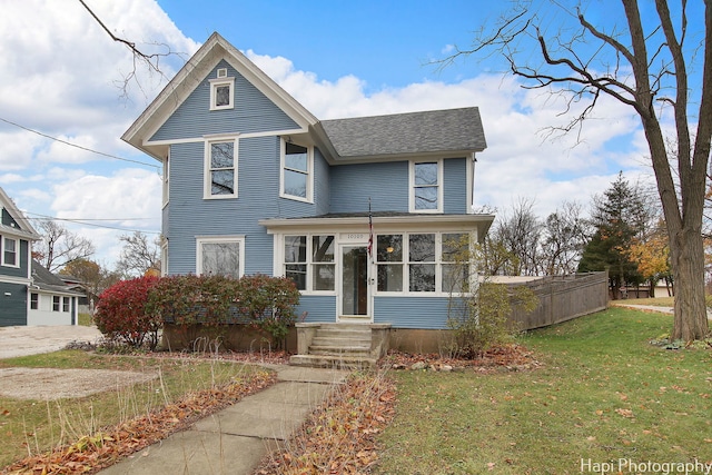 view of front property with a front lawn and a sunroom