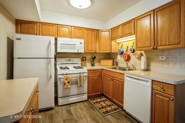 kitchen with tasteful backsplash, white appliances, sink, and dark wood-type flooring