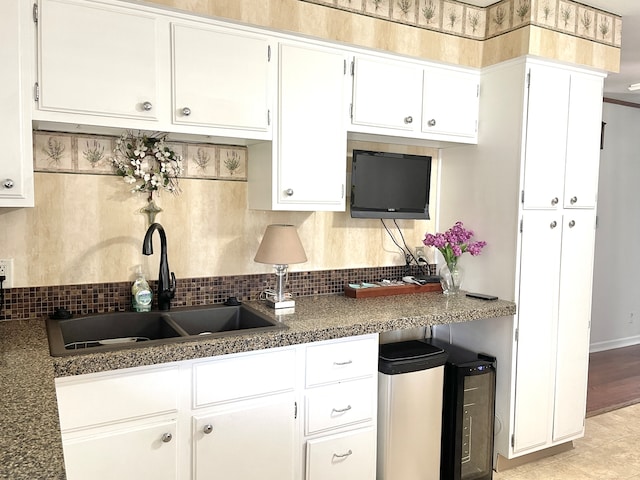 kitchen featuring white cabinets, backsplash, and sink