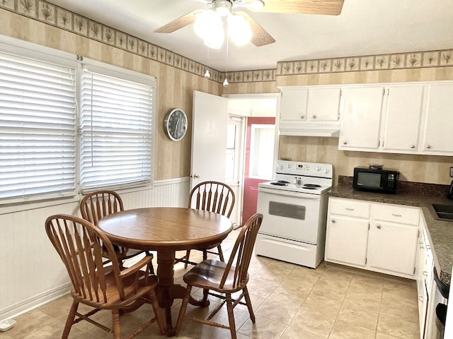 kitchen featuring white electric range oven, white cabinets, and ceiling fan