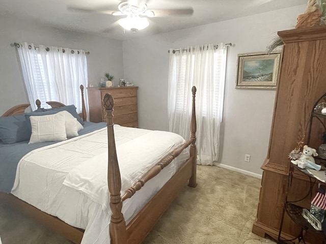 bedroom with ceiling fan and light carpet