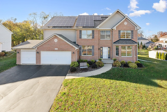 front of property with a front yard, solar panels, and a garage