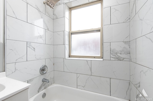 bathroom with tiled shower / bath, vanity, and a wealth of natural light