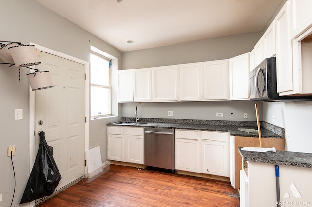 kitchen featuring white cabinetry, hardwood / wood-style floors, appliances with stainless steel finishes, and sink