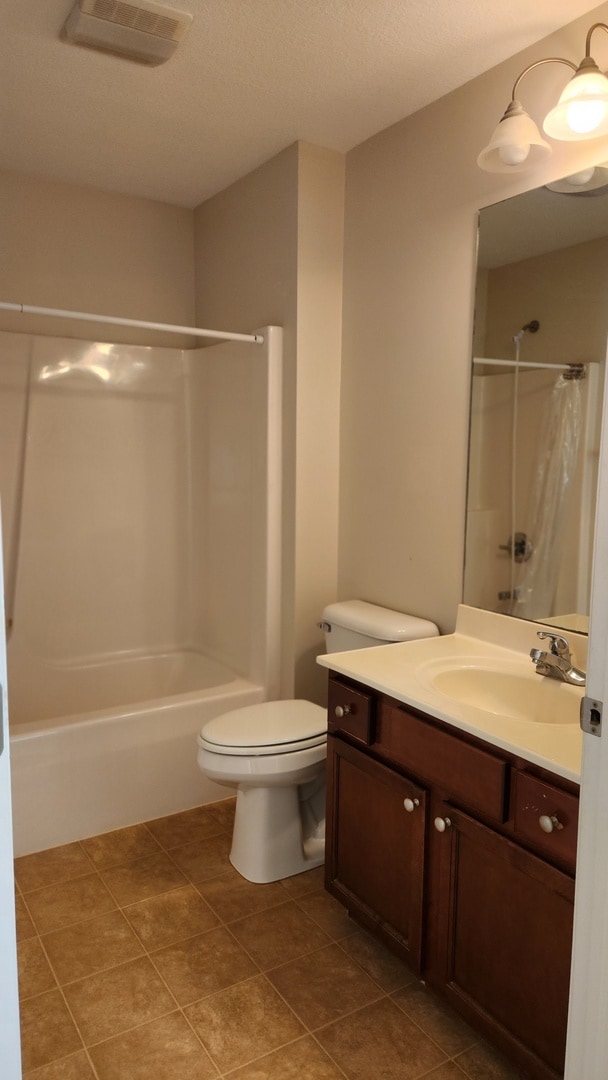 full bathroom with vanity, tile patterned floors, toilet, shower / bathtub combination with curtain, and a textured ceiling