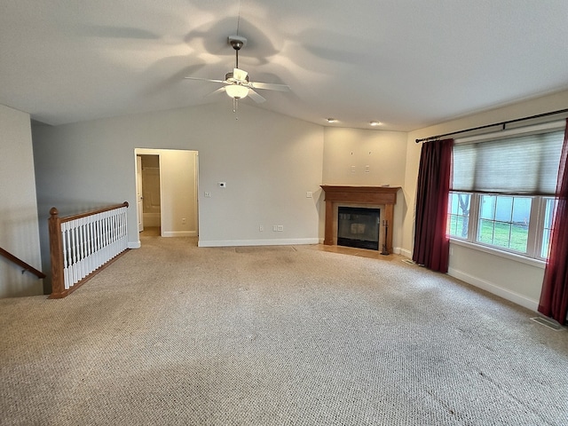 unfurnished living room with ceiling fan, light colored carpet, and lofted ceiling