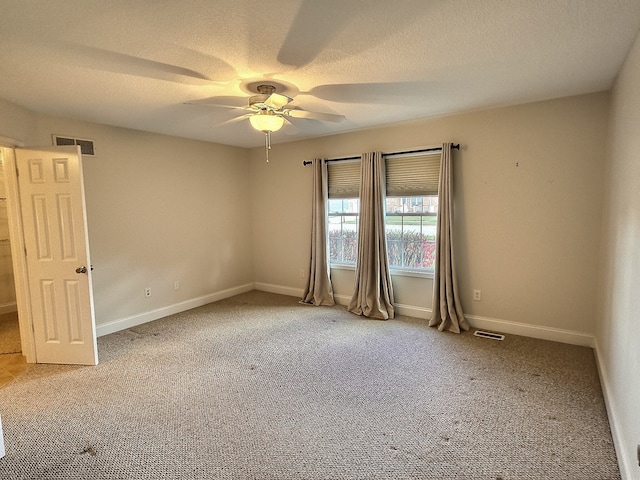 carpeted spare room featuring ceiling fan and a textured ceiling