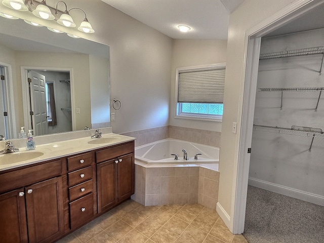 bathroom with tile patterned flooring, vanity, tiled bath, and vaulted ceiling