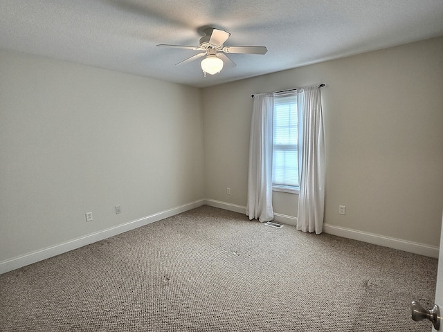 carpeted empty room with ceiling fan and a textured ceiling