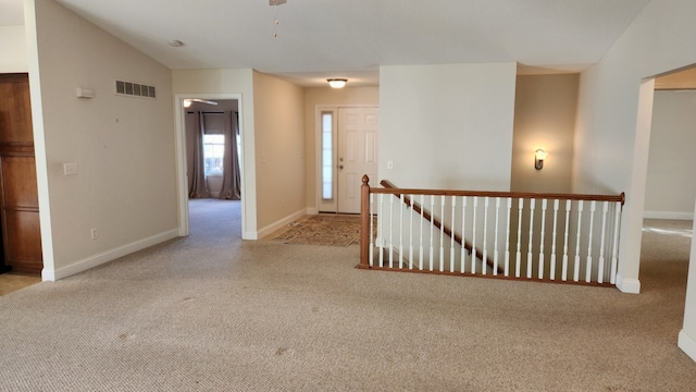 interior space featuring light colored carpet and vaulted ceiling