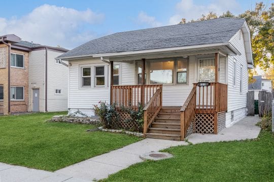 rear view of property with a porch and a lawn