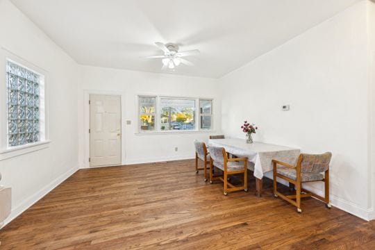 dining area with a wealth of natural light, dark wood-type flooring, and ceiling fan