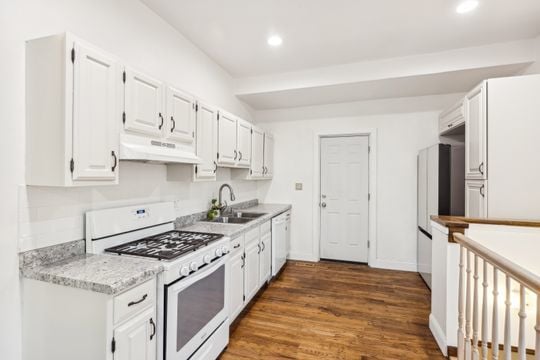 kitchen featuring dark hardwood / wood-style flooring, white cabinetry, white appliances, and sink