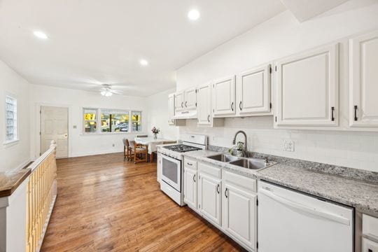 kitchen with plenty of natural light, white appliances, sink, and white cabinets