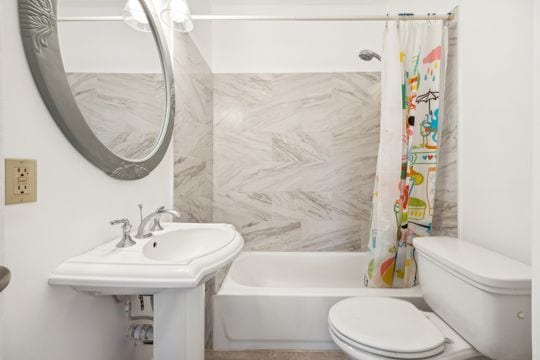 bathroom featuring shower / bath combo and toilet