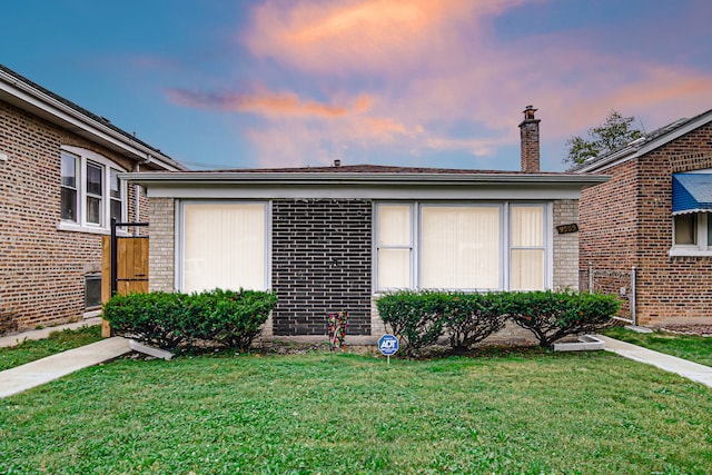 property exterior at dusk featuring a lawn