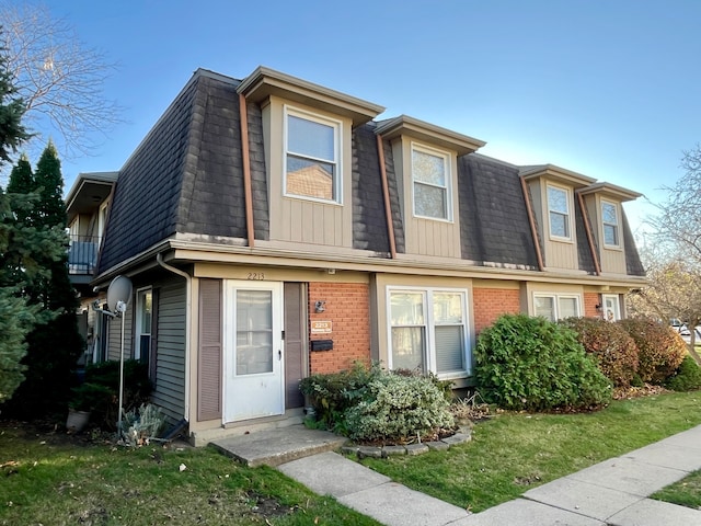 townhome / multi-family property with a balcony and a front yard