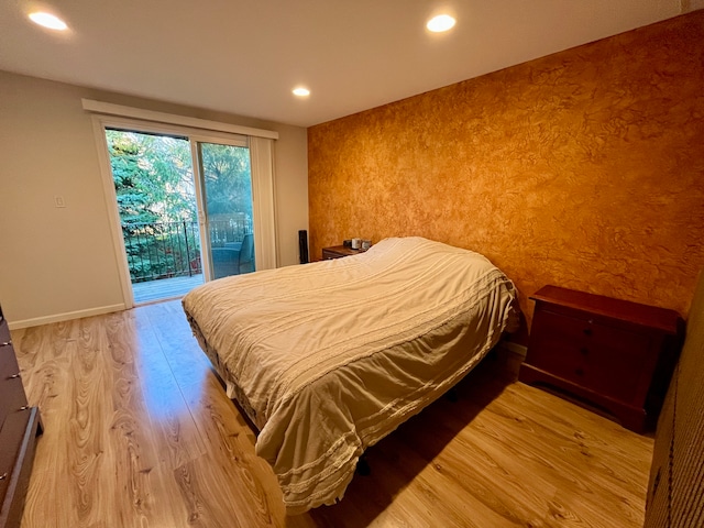 bedroom with hardwood / wood-style floors and access to outside