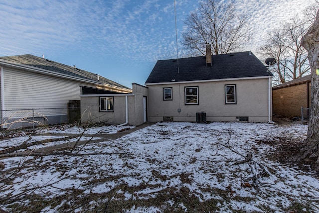 snow covered back of property featuring central AC