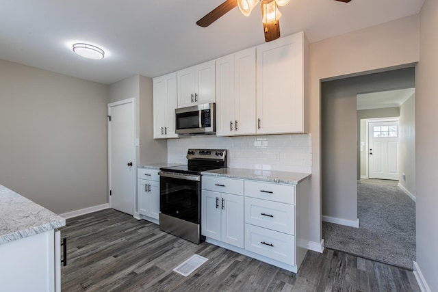 kitchen with white cabinetry, stainless steel appliances, dark hardwood / wood-style floors, and backsplash