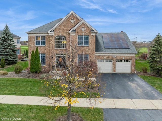 view of front of home with solar panels and a front yard