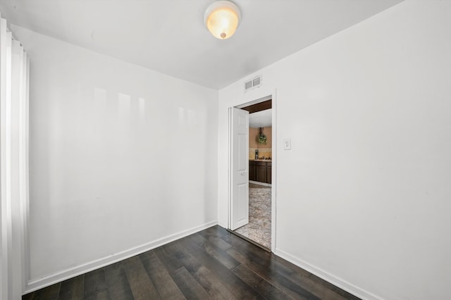 unfurnished room with dark hardwood / wood-style flooring